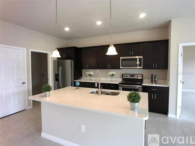 A kitchen with a white island and black cabinets.
