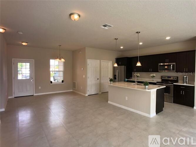 A spacious kitchen and living room with a large island in the middle.