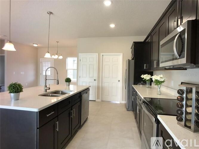 A kitchen with black cabinets and a white countertop.