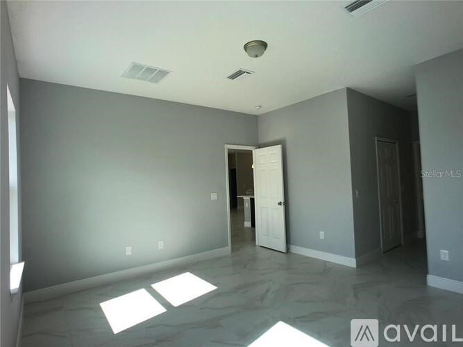 A spacious empty room with a doorway leading to another room.