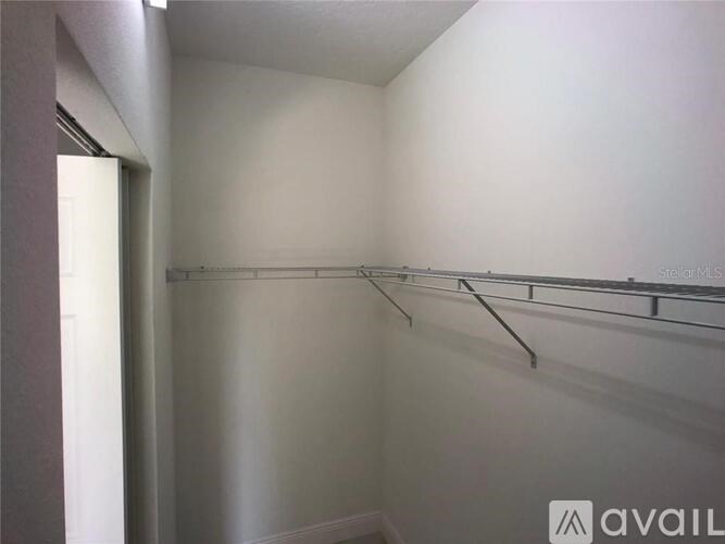 A white room with a long metal rack on the wall.