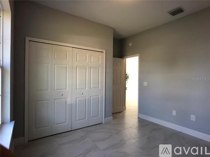 A large white door with a window above it in a room with a marble floor.