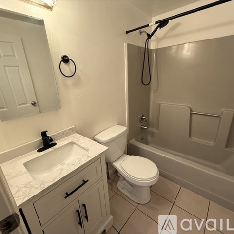 A bathroom with a toilet, sink, and tub.