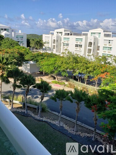 A view of a resort with palm trees and white buildings.
