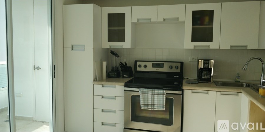 A kitchen with white cabinets and a black stove top oven.