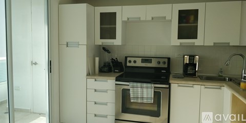 A kitchen with white cabinets and a black stove top oven.