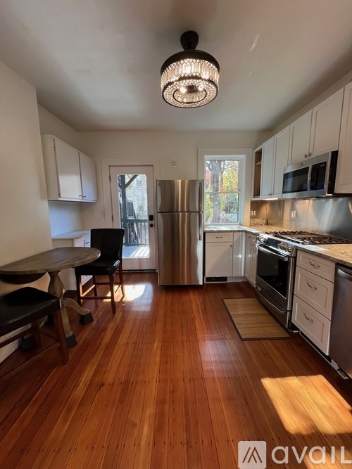 A kitchen with wooden floors and stainless steel appliances.