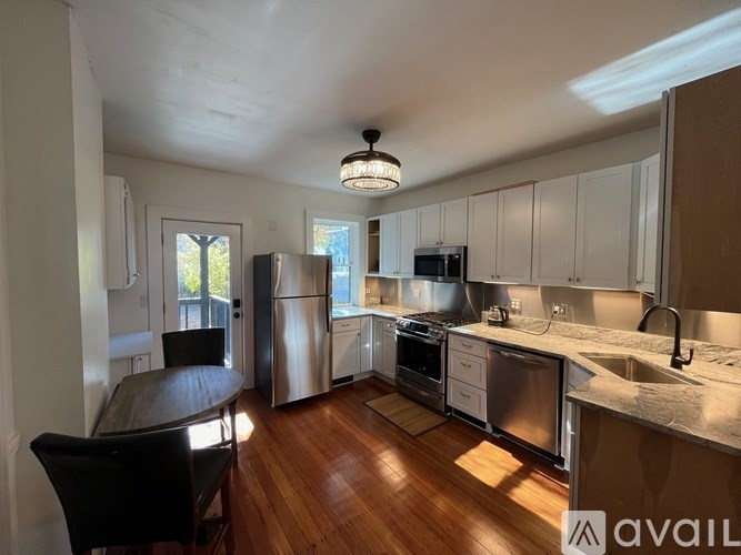 A kitchen with wooden floors and white cabinets.
