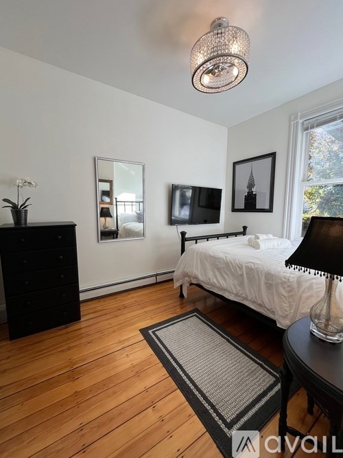 A bedroom with a bed, dresser, and mirror.
