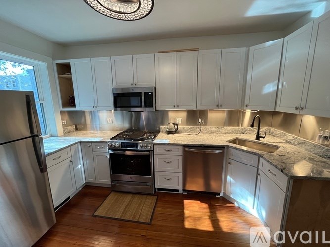 A kitchen with white cabinets and stainless steel appliances.