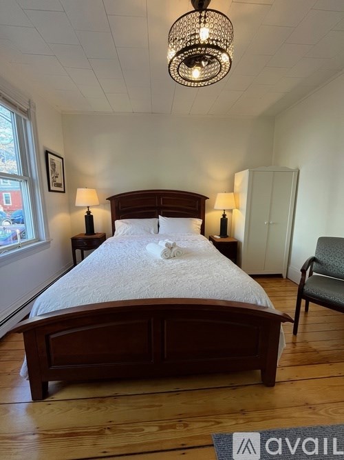 A bedroom with a large bed and a chandelier.