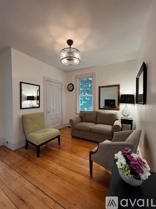 A living room with a wooden floor and a grey sofa.