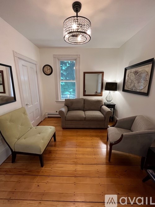 A living room with a couch, chair, and lamp.