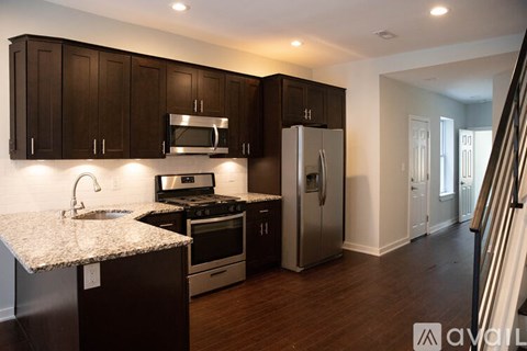 A kitchen with dark brown cabinets and stainless steel appliances.