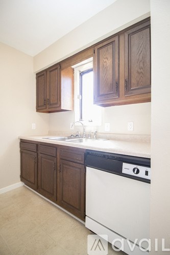 A kitchen with brown cabinets and a white dishwasher.