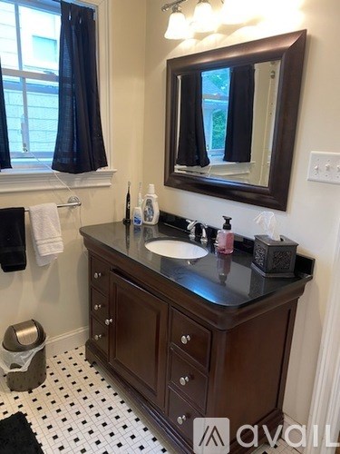 A bathroom with a brown vanity and a mirror.