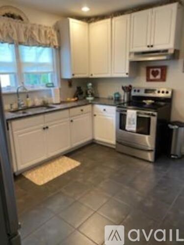 A kitchen with white cabinets and a black stove top.