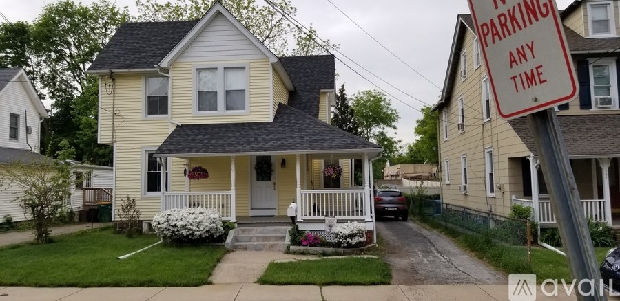 A house with a sign that says "PARKING ANY TIME" in front of it.