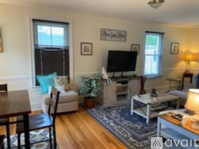 A living room with a couch, chair, and television.