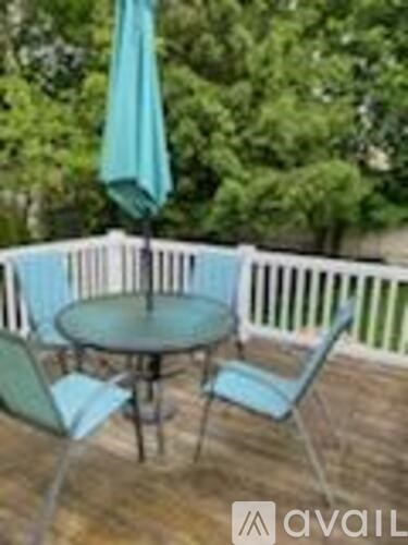 A patio with a table and chairs and an umbrella.