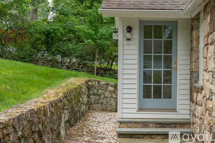 A house with a grey door and a stone wall.