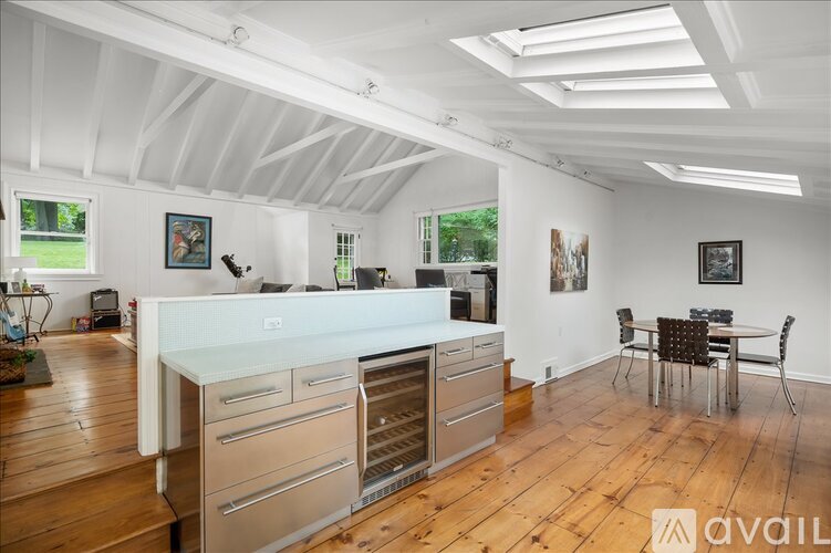 A kitchen with a white countertop and wooden floors.