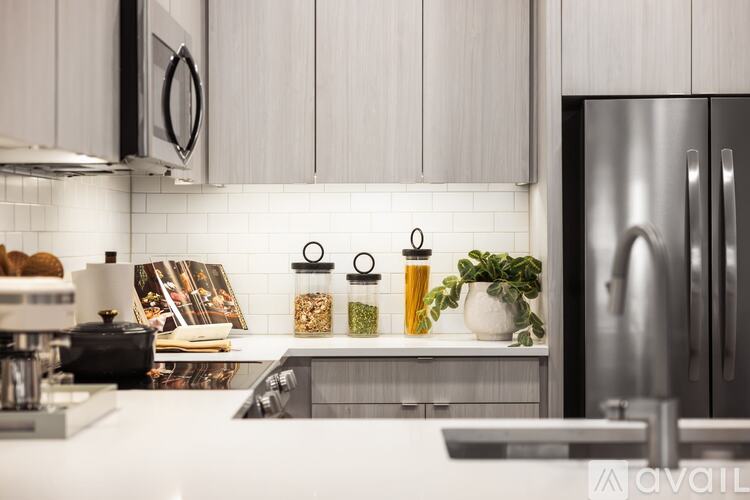 A kitchen with a white countertop and a stainless steel refrigerator.