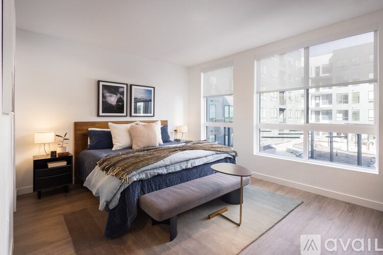 A bedroom with a large bed and a window overlooking a cityscape.