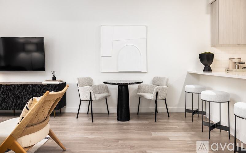 A modern living room with a white wall and a black and white artwork.