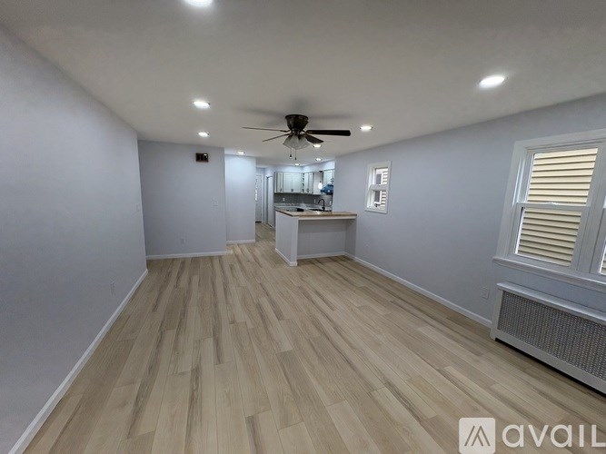 A room with wooden flooring and a ceiling fan.
