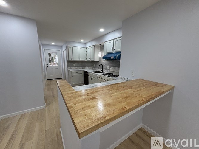 A kitchen with a wooden countertop and white cabinets.