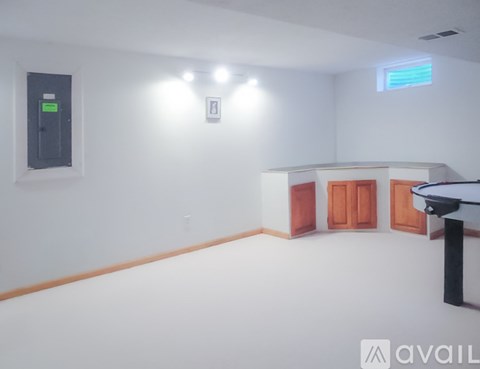 A room with a white wall and a black object on the left side.