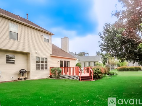 A house with a green lawn and a red deck.