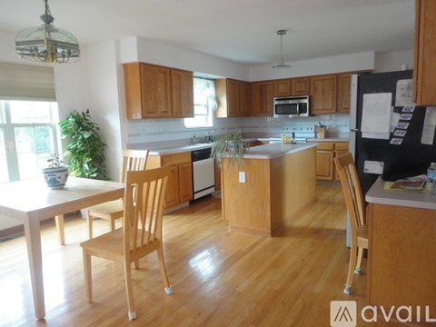 A kitchen with wooden cabinets and a black fridge.