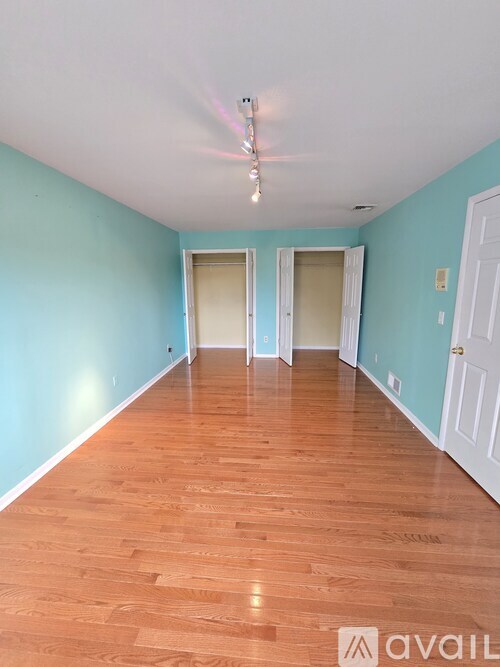 A long hallway with wood floors and white doors.
