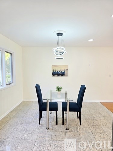 A dining room with a table and chairs.
