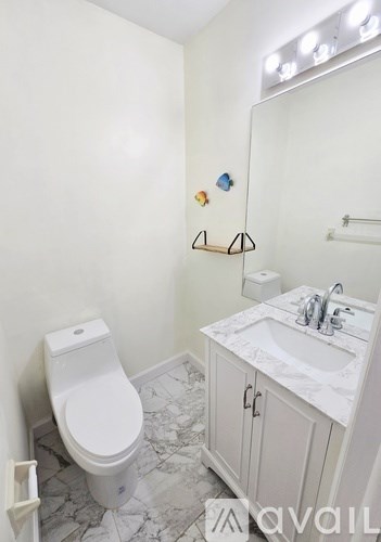 A bathroom with a toilet, sink, and a mirror.