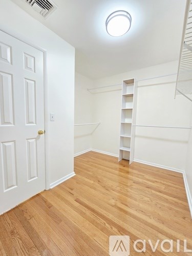 A room with wooden flooring and a white door.