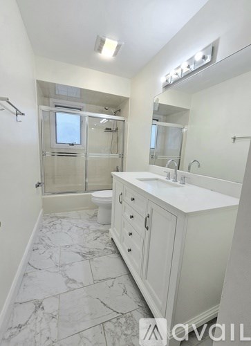 A bathroom with marble flooring and a walk-in shower.