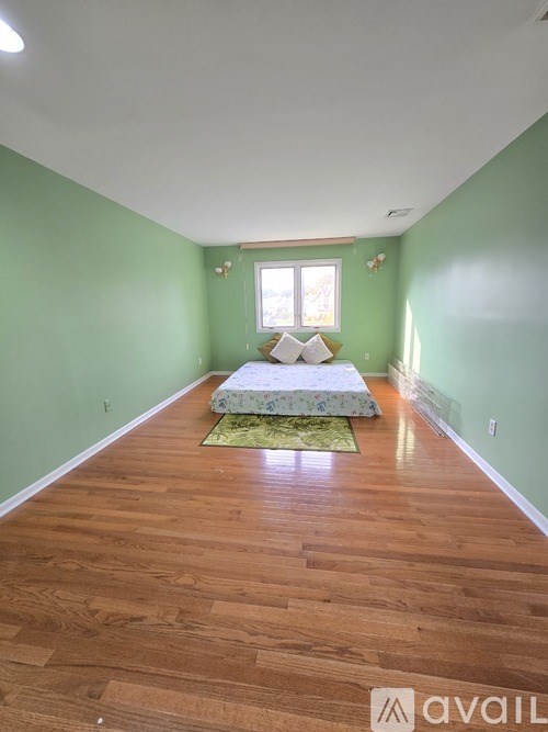 A bedroom with a bed and a green wall.