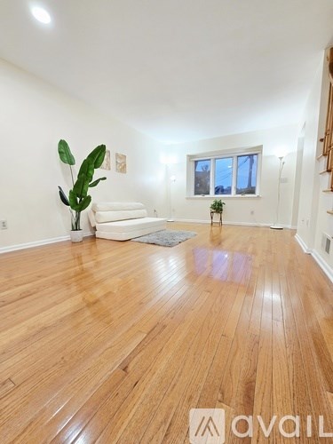 A room with wooden flooring and a white sofa.