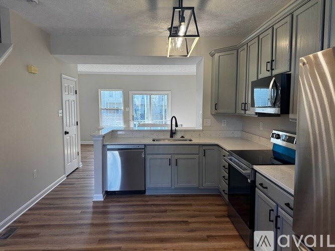 A kitchen with wooden floors and stainless steel appliances.