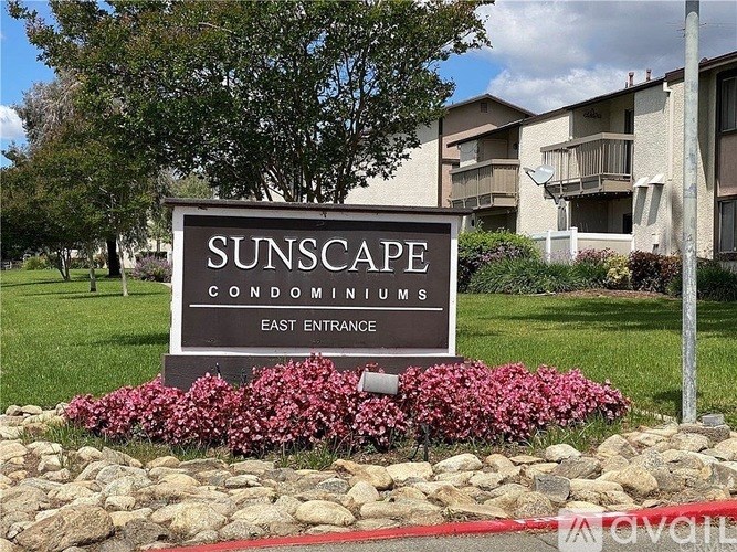 A sign for Sunscape Condominiums with a red line in the foreground.