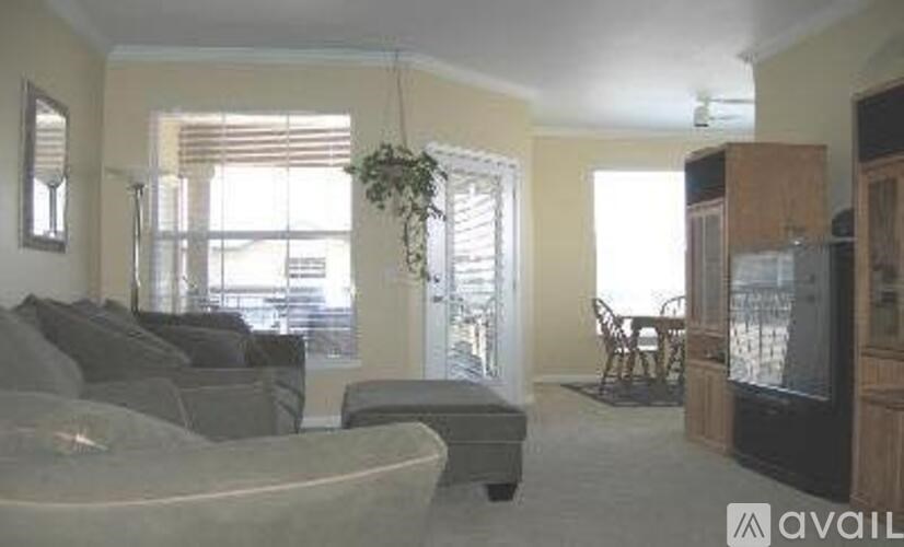 A living room with a grey couch and a wooden cabinet.