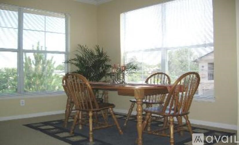A dining room with a table and chairs.