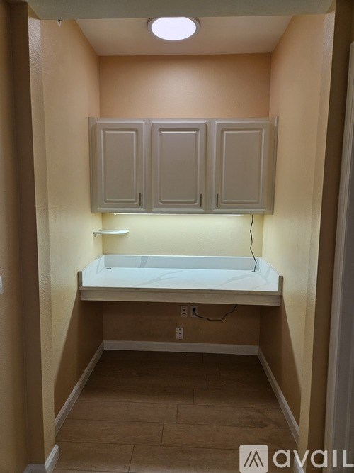 A small bathroom with a toilet and a cabinet.