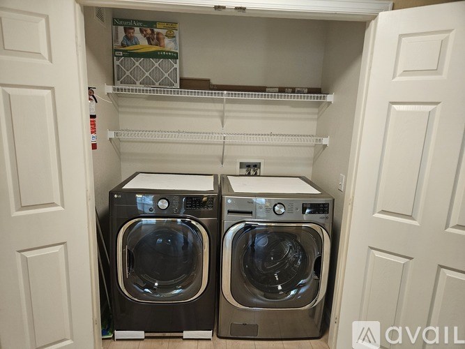Two front loading washing machines in a small laundry room.