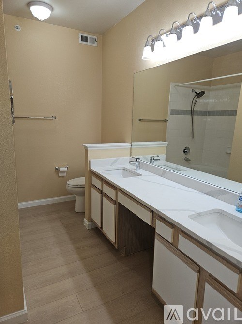 A bathroom with a white counter top and a white sink.