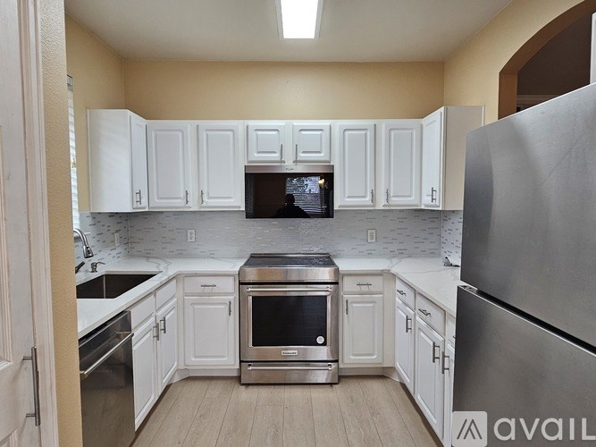 A kitchen with white cabinets and stainless steel appliances.