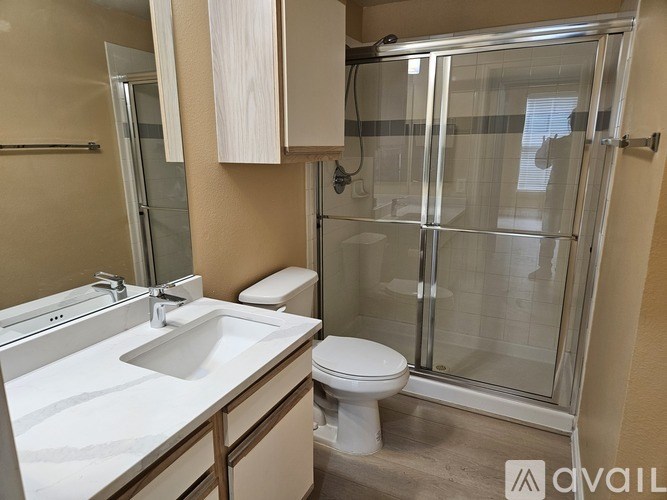 A bathroom with a sink, toilet, and shower.